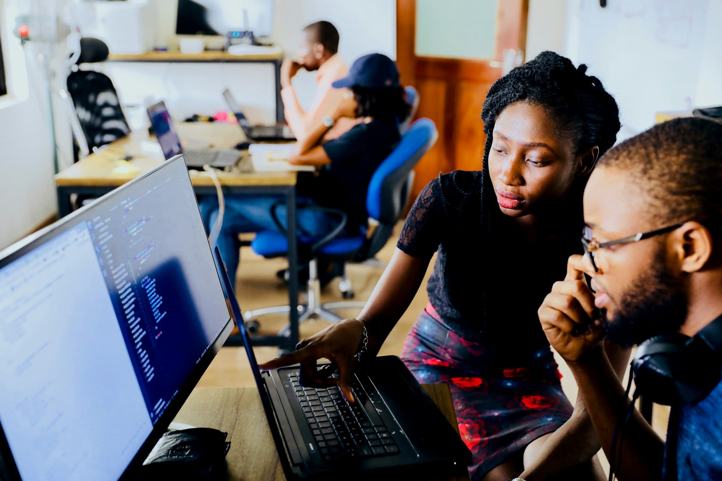 Two people reviewing code together at a monitor during a session at NESA by Makers in Lagos, Nigeria
