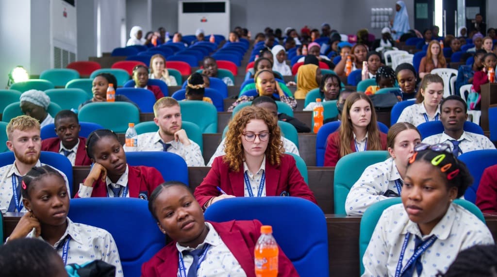 Diverse youth delegates and scholars in lecture hall at YAG global conference