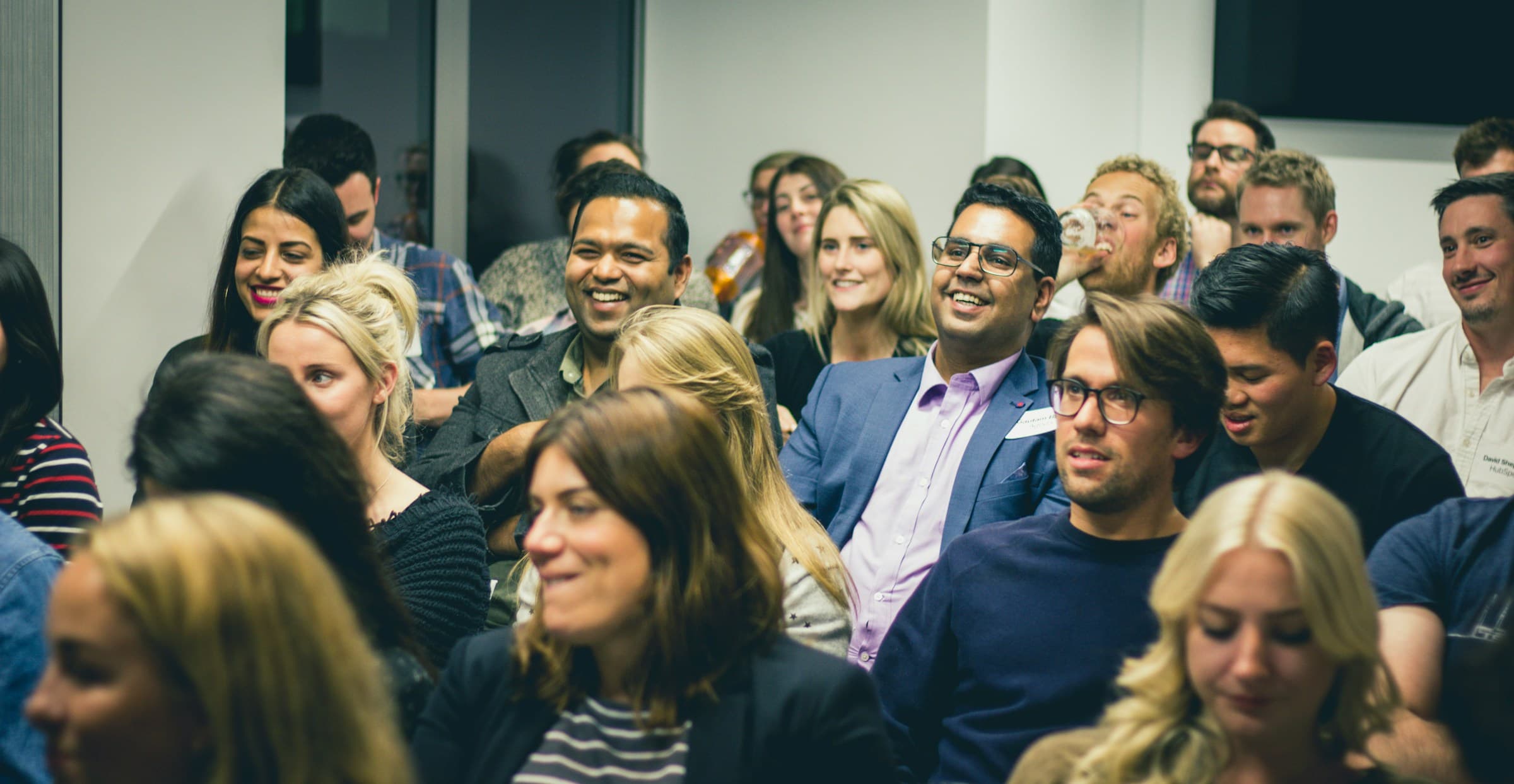 A diverse group of adults listening attentively during a professional seminar